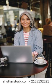 Happy Mature Lady Working At City Cafe