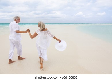 Happy mature male female Caucasian couple living a healthy outdoor leisure lifestyle on a Caribbean beach