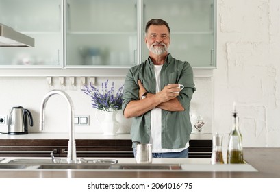 Happy mature man drinking coffee at home in the kitchen, enjoying hot drink in the morning on weekend - Powered by Shutterstock