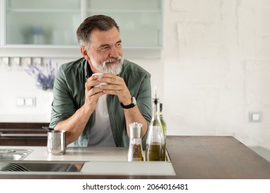 Happy mature man drinking coffee at home in the kitchen, enjoying hot drink in the morning on weekend - Powered by Shutterstock