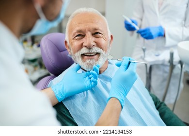 Happy mature man during teeth check-up at dental clinic.