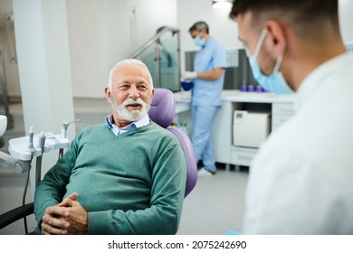 Happy mature man and his dentist communicating during dental appointment at clinic. - Powered by Shutterstock