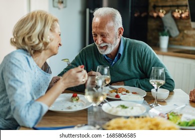 Happy Mature Man And His Wife Talking While Having Lunch Together In Dining Room. 