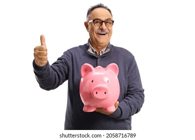 Happy mature man holding a piggy bank and gesturing a thumb up sign isolated on white background