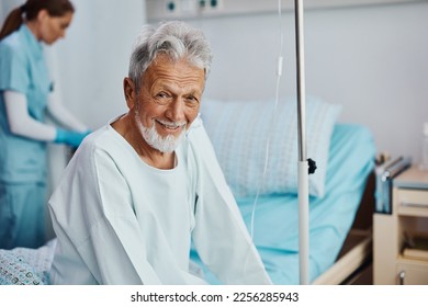 Happy mature man recovering in the hospital and looking at camera. - Powered by Shutterstock