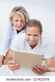 Happy Mature Man Using Digital Tablet Woman Looking From Behind