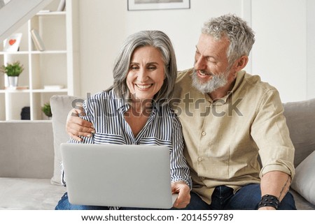 Similar – Image, Stock Photo A middle-aged couple hugging each other and observing a sunset sea, we see them from the back