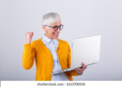 Happy Mature Middle Aged Elderly Business Woman Winner Excited By Reading Good News Looking At Laptop, Glad Senior Older Lady Watching Celebrating Online Bid Bet Win Or Great Result Victory Concept