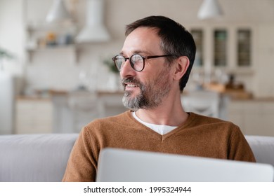 Happy mature middle-aged man father husband using laptop at home, working from home office, watching movies webinars online as a freelancer on lockdown. - Powered by Shutterstock