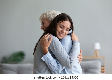 Happy mature mother and grown-up adult daughter hug cuddle share close intimate moment together, smiling elderly mom and millennial girl child embrace make peace reconcile after fight - Shutterstock ID 1681615300