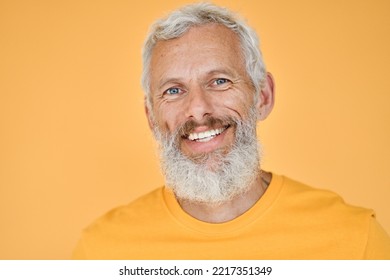 Happy Mature Older Bearded Man, Smiling Cool Middle Aged Gray Haired Old Senior Confident Hipster Wearing Yellow T-shirt Standing Isolated On Yellow Background, Close Up Headshot Portrait.