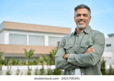 Happy mature older Latin man new property buyer modern villa owner or realtor salesman standing outside home, smiling middle aged homeowner posing outdoor near country house. Portrait. - Powered by Shutterstock