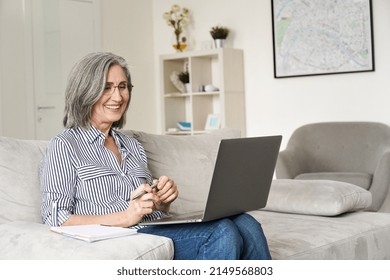 Happy Mature Older Senior Adult Professional Business Woman Working On Laptop From Home Office, Watching Online Training Webinar Using Computer E Learning Class, Having Virtual Video Call Meeting.