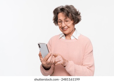 Happy mature senior caucasian woman holding smartphone using mobile online apps, browsing. Smiling old elderly lady texting sms message chatting with family on phone isolated over white background. - Powered by Shutterstock