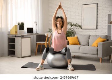 Happy mature sporty woman training with fitness ball at home - Powered by Shutterstock