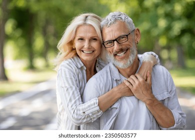 Happy Mature Spouses. Portrait of cheerful older couple hugging and smiling at camera, joyful senior man and woman embracing while posing together outdoors, enjoying romantic date outside, closeup - Powered by Shutterstock