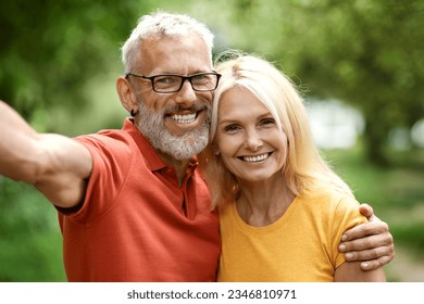 Happy mature spouses taking selfie together outdoors, closeup shot of cheerful senior couple hugging and posing to camera while spending time in their garden, enjoying retirement lifestyle - Powered by Shutterstock