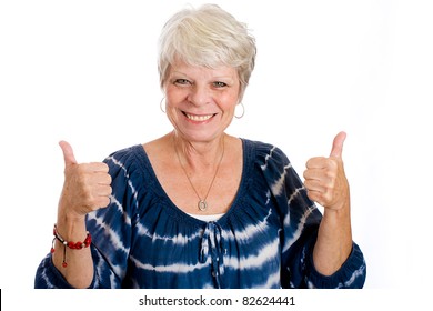 Happy, mature, white haired woman with two thumbs up.