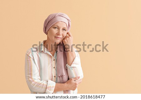 Happy mature woman after chemotherapy on color background