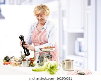 Happy Mature Woman Cooking In Her Kitchen