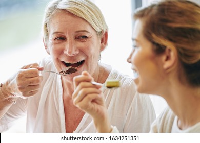 Happy Mature Woman Eating Delicious Chocolate Dessert And Listening To Her Daughter