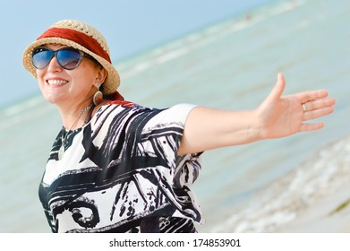 Happy Mature Woman Enjoying Breeze On Seashore