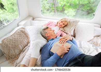 Happy Mature Woman And Her Husband Relaxing On Bed In Their Motorhome During Camping Vacation