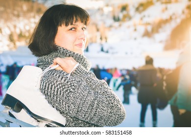 Happy Mature Woman Holds Skates At Medeo Ice Rink. Mother Has Winter Ice Skating Activities. Almaty