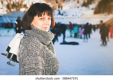 Happy Mature Woman Holds Skates At Medeo Ice Rink. Mother Has Winter Ice Skating Activities. Almaty