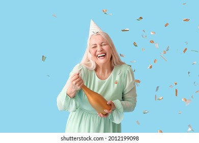 Happy Mature Woman In Party Hat And With Champagne On Color Background