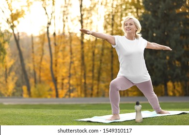 Happy Mature Woman Practicing Yoga In Park. Active Lifestyle