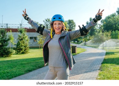 Happy Mature Woman Rollerblading In The Park Wearing Helmet, Protective Helmet, Knee Pads, Elbow Pads