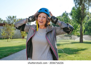 Happy Mature Woman Rollerblading In The Park Wearing Helmet, Protective Helmet, Knee Pads, Elbow Pads