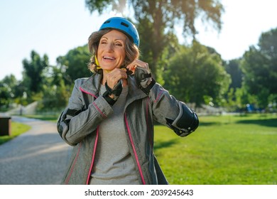 Happy Mature Woman Rollerblading In The Park Wearing Helmet, Protective Helmet, Knee Pads, Elbow Pads