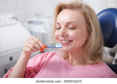 Happy Mature Woman Smiling With Eyes Closed, Holding Toothbrush With Toothpaste