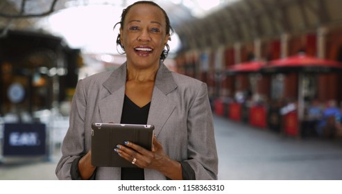 Happy Mature Woman Using Digital Tablet And Talking To Camera Outside