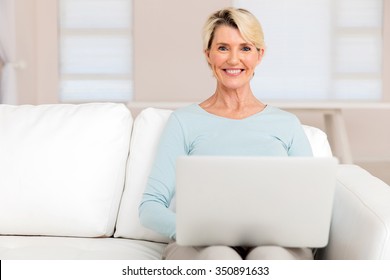 Happy Mature Woman Using Laptop At Home