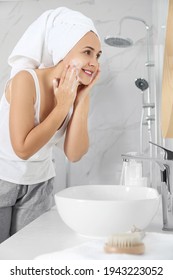 Happy Mature Woman Washing Face In Bathroom