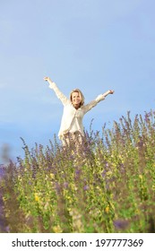 Happy Matured Woman In A Meadow With Spread Arms