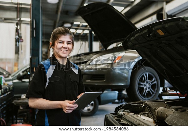 Happy mechanic\
running a diagnostic on a\
vehicle