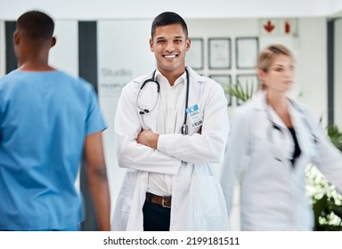 Happy, Medical And Doctor In Hospital With Smile And Confident, Arms Crossed In Busy Hallway. Male, Surgeon And Healthcare Specialist Physician In Hospital. Staff, Clinical Internship.