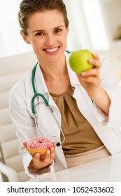 Happy Medical Doctor Woman Giving Apple Instead Of Donut