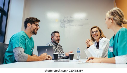 Happy Medical Team Having A Meeting In Conference Room In Hospital. Doctors At Briefing In Hospital Office.