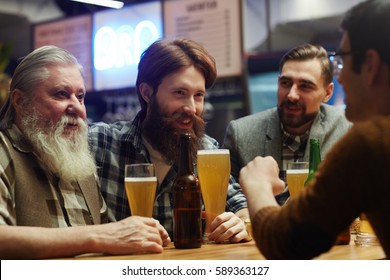 Happy Men With Beer Spending Traditional Irish Holiday In Pub