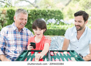 Happy Men playing backgammon outdoors