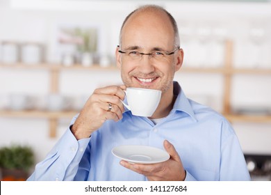 Happy Mid Age Man Drinking Coffee At Home