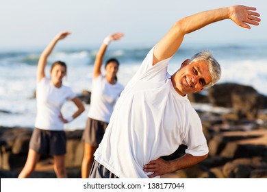 happy mid age man exercising at the beach with his family - Powered by Shutterstock