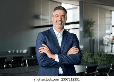 Happy mid aged business man ceo standing in office arms crossed. Smiling mature confident professional executive manager, proud lawyer, confident businessman leader wearing blue suit, portrait. - Shutterstock ID 2307212331