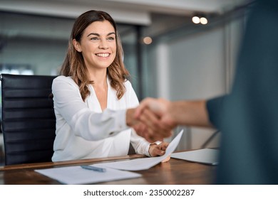 Happy mid aged business woman manager handshake at office meeting. Smiling female hr hires recruit at job interview, bank insurance agent, lawyer making contract deal with client at work. Onboarding. - Powered by Shutterstock