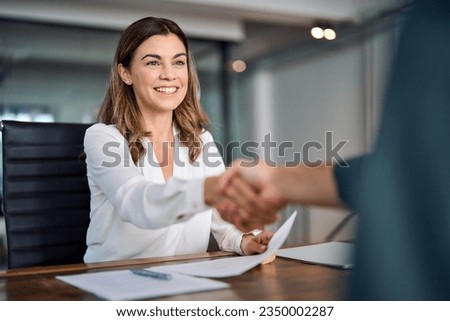 Happy mid aged business woman manager handshake at office meeting. Smiling female hr hires recruit at job interview, bank insurance agent, lawyer making contract deal with client at work. Onboarding.